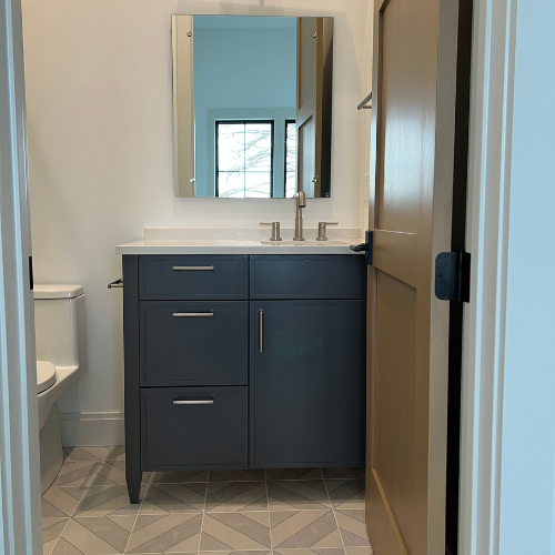 showroom bathroom, blue cabinets, sink, mirror